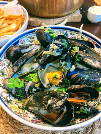 bowl of mussels next to bowl of fries